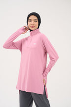 Woman in hijab in the Light Pink Inspira modest top, one hand raised to the collar